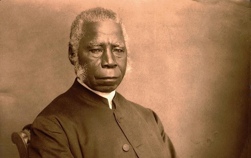 Photographic portrait of Bishop Samuel Ajayi Crowther in later life, white-haired, seated in a clerical coat against a plain studio backdrop.
